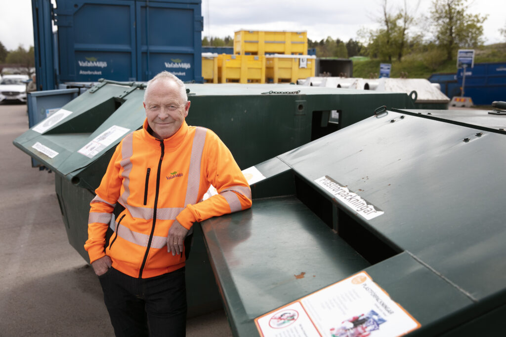 en man som står vid en återvinningsstation