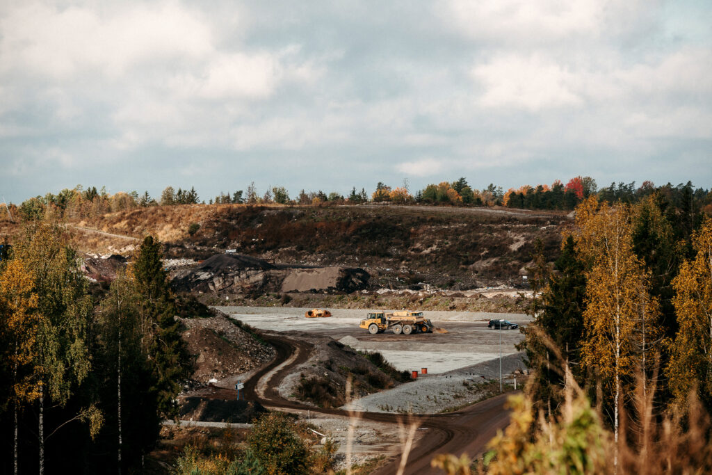Maskin som åker i ett större sand- och jordtag.