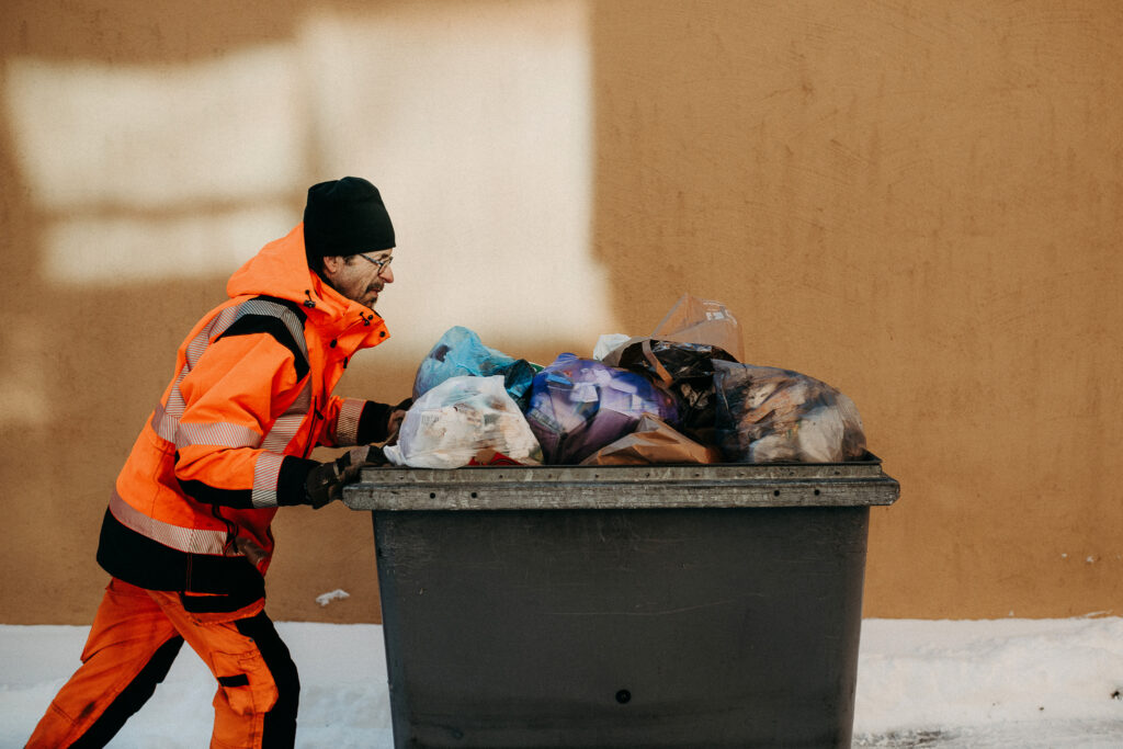 Man skjuter ett sopkärl framför sig